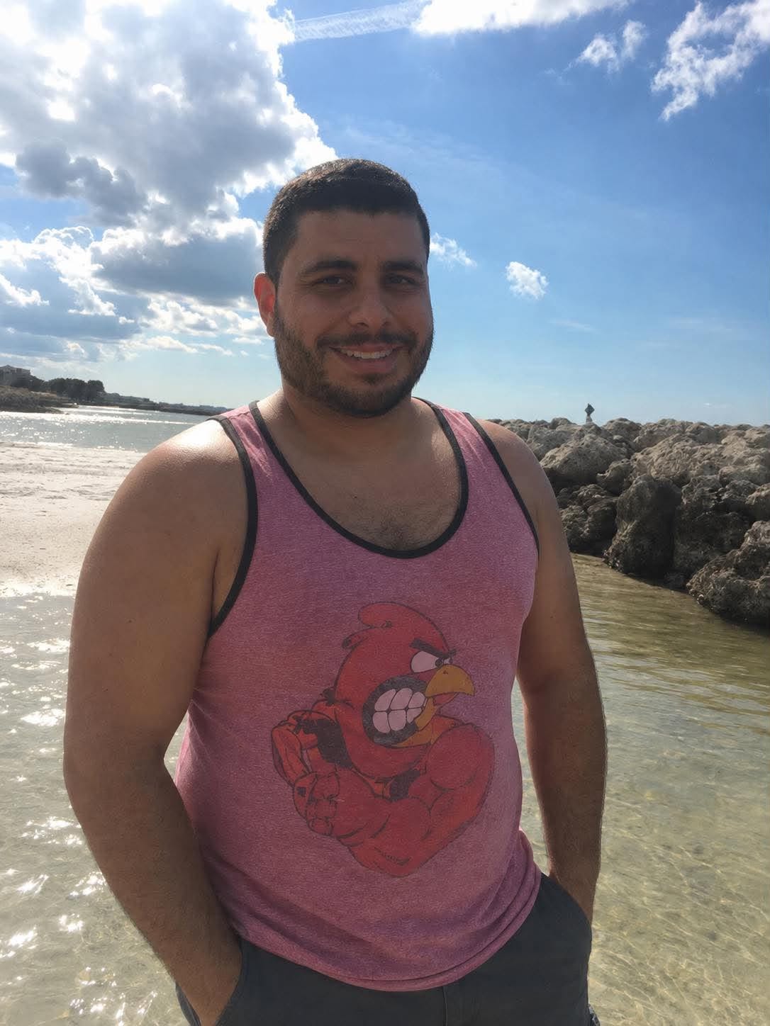 Hector at the beach in a pink tank top